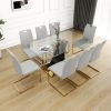 Modern style glass dining table, elegant transparent design, solid support base, grey dining chair set, gold-plated chair legs, suitable for restauran